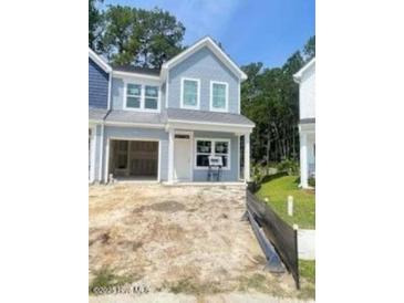 Charming two-story home with light blue siding and an attached open garage at 804 Nw Palm Frond Way # 804, Calabash, NC 28467