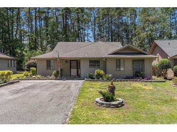 Charming single-story home featuring a well-manicured lawn and inviting curb appeal nestled amongst the trees at 137 Hickory Dr., Conway, SC 29526