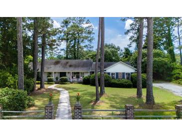 Beautiful one story home featuring a large front yard, mature trees and charming curb appeal at 59 Bay Tree Ln., Pawleys Island, SC 29585