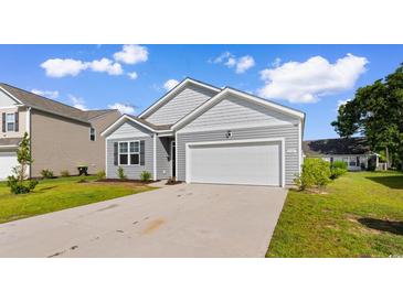 Charming single-story home featuring gray siding, an attached garage, and a well-maintained lawn at 1128 Sennema Circle, Myrtle Beach, SC 29588