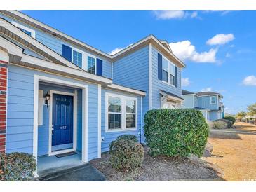 Charming two-story blue townhome featuring well-maintained landscaping and a welcoming entrance at 1857 Culbertson Ave. # 1857, Myrtle Beach, SC 29577