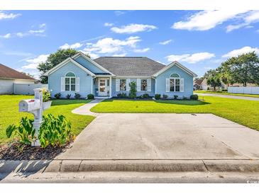 Charming light blue home with landscaped front yard, driveway, and well-maintained lawn at 3907 Stillwood Dr., Myrtle Beach, SC 29588