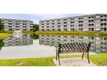 Scenic view of condos overlooking a pond with a fountain and a bench in the foreground at 4522 N Plantation Harbour Dr. # E7, Little River, SC 29566