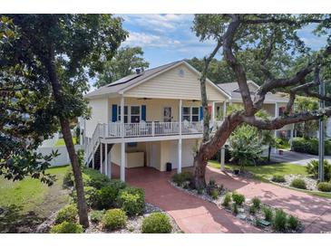 Charming two-story home features a spacious porch, lovely landscaping, and a brick driveway leading to ample parking at 505 41St Ave. S, North Myrtle Beach, SC 29582