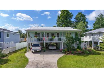 Charming two-story home featuring a covered porch, driveway parking, and a beautifully landscaped front yard at 5867 Rosewood Dr., Myrtle Beach, SC 29588