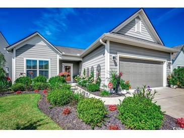 Charming home featuring manicured landscaping, gray siding, and a welcoming front entrance at 6430 Cascata Dr., Myrtle Beach, SC 29572