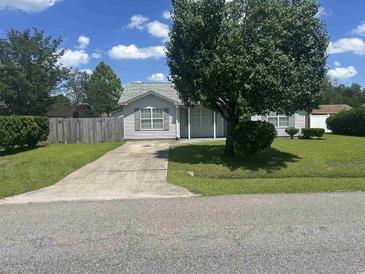 Charming home with a well-maintained lawn, mature tree, and convenient driveway at 706 Jamie Ln., Conway, SC 29526