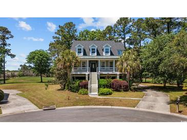 Stunning elevated home with beautiful landscaping, inviting stairs, and a charming front porch at 854 Falkirk St., Myrtle Beach, SC 29579