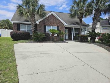 Charming brick home with palm trees and a spacious driveway at 1028 Cherry Tree Ln., North Myrtle Beach, SC 29582