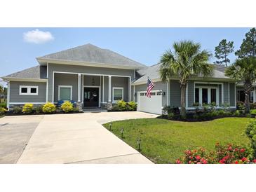 Stunning single-story home with a well-manicured lawn and an attached two-car garage at 1455 Whooping Crane Dr., Conway, SC 29526