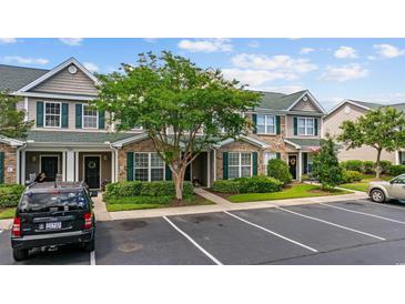 Charming townhome featuring brick accents, green shutters, well-maintained landscaping, and dedicated parking at 155 Chenoa Dr. # D, Murrells Inlet, SC 29576