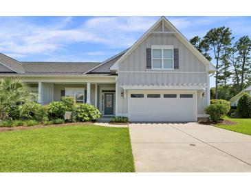 Charming single-Gathering home featuring an attached two-car garage, well-manicured lawn, and inviting curb appeal at 1584 Sand Harbor Cir. # 1584, Ocean Isle Beach, NC 28469