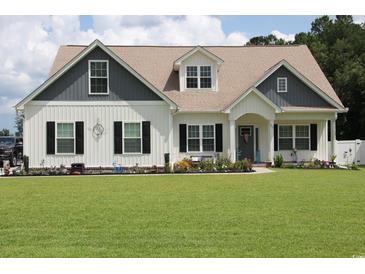 Charming two-story home with a well-manicured lawn and inviting curb appeal with flower beds at 242 Four Mile Rd., Conway, SC 29526