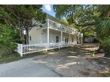 Charming two-story home with a large, inviting balcony and picket fence at 304 1St Ave. N, Myrtle Beach, SC 29577