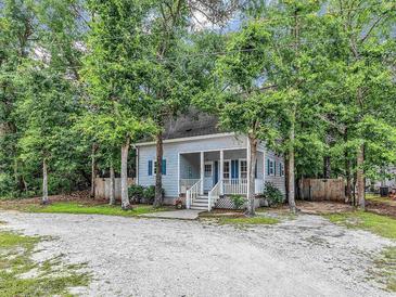 Charming single story home featuring a porch and an abundance of trees at 3969 Murrells Inlet Rd., Murrells Inlet, SC 29576