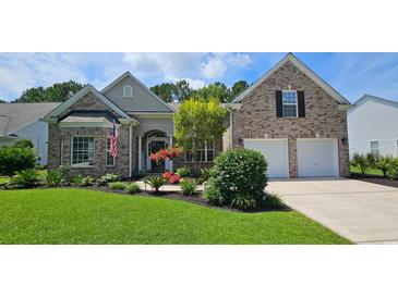 Beautiful brick home featuring a two-car garage, manicured lawn, and colorful landscaping at 6400 Longwood Dr., Murrells Inlet, SC 29576