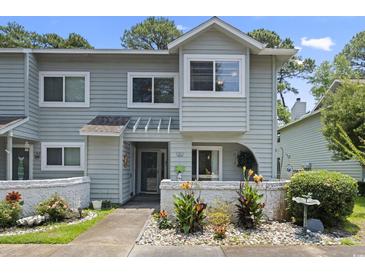 Charming two-story home with light gray siding and a well-manicured front yard with tasteful landscaping at 81 Shadow Moss Pl. # 81, North Myrtle Beach, SC 29582