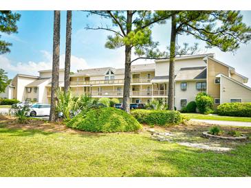 Well-maintained condo building with multi-level balconies and mature landscaping creating a tranquil, inviting atmosphere at 1025 Plantation Dr. # 2413/2414, Little River, SC 29566