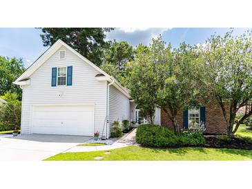 Charming home featuring a two-car garage, brick accents, and mature landscaping, offering great curb appeal at 1409 Ashwood Circle, Surfside Beach, SC 29575