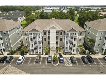 Aerial view showcases the building's architecture, and parking with neatly arranged parking spaces at 181 Ella Kinley Circle # 305, Myrtle Beach, SC 29588