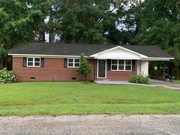 Charming one-story brick home with well-maintained lawn and mature trees at 3110 Pinewood Dr., Loris, SC 29569