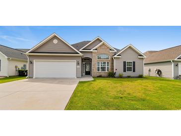 Charming home featuring a two-car garage, manicured lawn, and a blend of stone and vinyl siding at 347 Leste Rd., Myrtle Beach, SC 29588