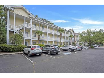 Three-story condo complex featuring balconies, white railings, and parking at 4221 Hibiscus Dr. # 8-203, Little River, SC 29566