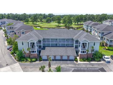 Three-story condo building boasts garages, balconies, and a picturesque golf course view at 4827 Orchid Way # 1-203, Myrtle Beach, SC 29577
