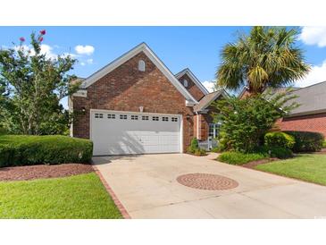 Charming single story brick home with a well manicured lawn, lush landscaping and a two car garage at 5712 Whistling Duck Dr., North Myrtle Beach, SC 29582
