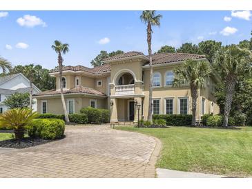 Stunning Mediterranean-style home with a tile roof, brick driveway, and lush landscaping at 664 Oxbow Dr., Myrtle Beach, SC 29579