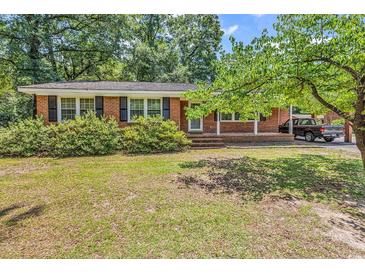 Charming brick home featuring a well-maintained front yard and covered carport at 823 Bellamy Ave., Murrells Inlet, SC 29576