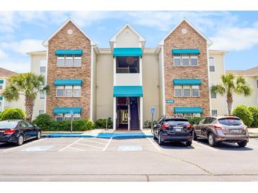 Apartment complex featuring covered balconies, parking, and blue awnings adding a pop of color at 9755 Leyland Dr. # 2, Myrtle Beach, SC 29572