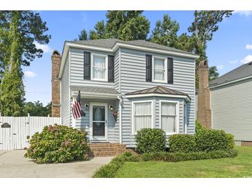 Charming two-story home featuring a well-manicured lawn, an American flag, and a welcoming front entrance at 1575 Victoria Ln., Myrtle Beach, SC 29577