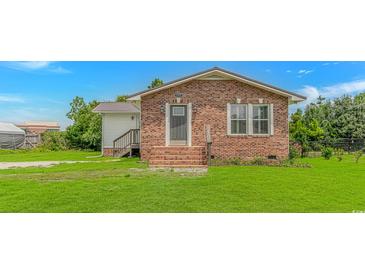 Charming brick home with a well-manicured lawn and inviting front entrance at 175 Cypress Ln., Little River, SC 29566