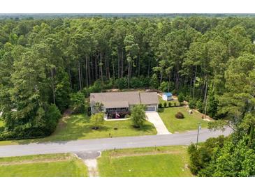 An aerial view of a quaint single-Gathering home nestled among mature trees and greenery, offering privacy at 2135 Starduster Ln., Little River, SC 29566