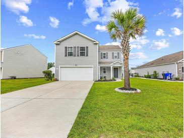 Charming two-story home featuring a well-manicured lawn and a driveway leading to an attached two-car garage at 317 Truce St., Myrtle Beach, SC 29588