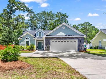 Charming two-story home featuring stone accents, manicured lawn, and a spacious two-car garage at 3864 Journeys End Rd., Murrells Inlet, SC 29576