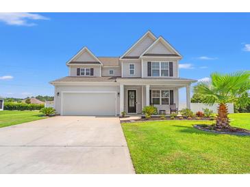 Charming two-story home with a well-manicured lawn and inviting front porch on a beautiful sunny day at 405 Spring View Ct., Little River, SC 29566