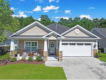 Charming single-story home with a well-manicured lawn, two-car garage and inviting front porch at 428 Arlington Circle, Murrells Inlet, SC 29576