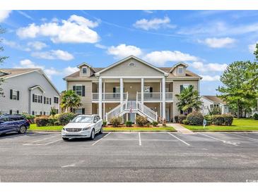 Inviting condo with covered front porch and white railings, landscaping, and ample parking at 447 Mahogany Dr. # 102, Murrells Inlet, SC 29576