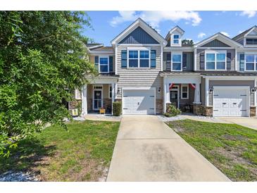 Charming townhome with stone accents, attached garage, and well-maintained landscaping at 468 Papyrus Circle # 468, Little River, SC 29566