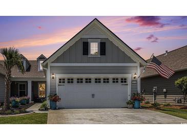 Attached two-car garage with flowerpots and an American flag at 5826 Cremona Dr., Myrtle Beach, SC 29577