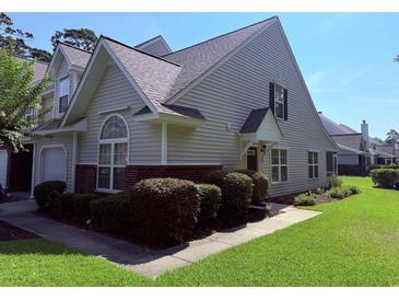 Charming home with beige siding, brick accents, manicured landscaping, and a well-maintained lawn at 62 4 Rye Grass Ln. # 4, Pawleys Island, SC 29585