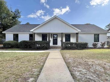 Charming one-story home with white brick, dark accents, and a well-maintained front yard at 7610 Driftwood Dr., Myrtle Beach, SC 29572