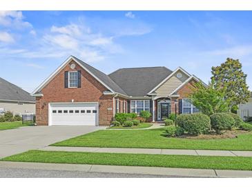 Charming brick home featuring a well-manicured lawn, attached garage, and beautiful landscaping at 8708 Coosaw Ct., Myrtle Beach, SC 29577