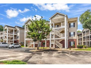 Attractive condo buildings with parking, greenery, brick accents, and welcoming staircases to covered outdoor walkways at 1058 Sea Mountain Hwy. # 102, North Myrtle Beach, SC 29582