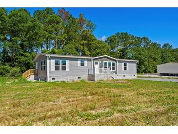 Inviting single-story home with gray siding, white trim and front porch at 1126 Amanda Lane, Loris, SC 29569