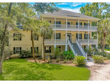 Charming two-story home with a double front porch, landscaped yard, and blue skies at 1176 Old Plantation Dr., Pawleys Island, SC 29585