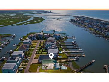 Stunning aerial view of waterfront home with private dock, pool and lush landscaping at 1510 North Shore Dr, Sunset Beach, NC 28468