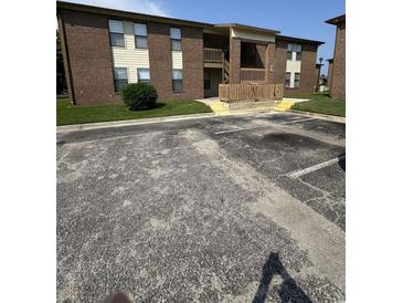 Brick apartment building with a wooden porch and stairs at 2005 Greens Blvd. # D301, Myrtle Beach, SC 29577
